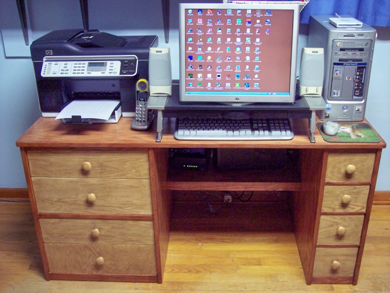 shows a photo of the desk with computer components on top